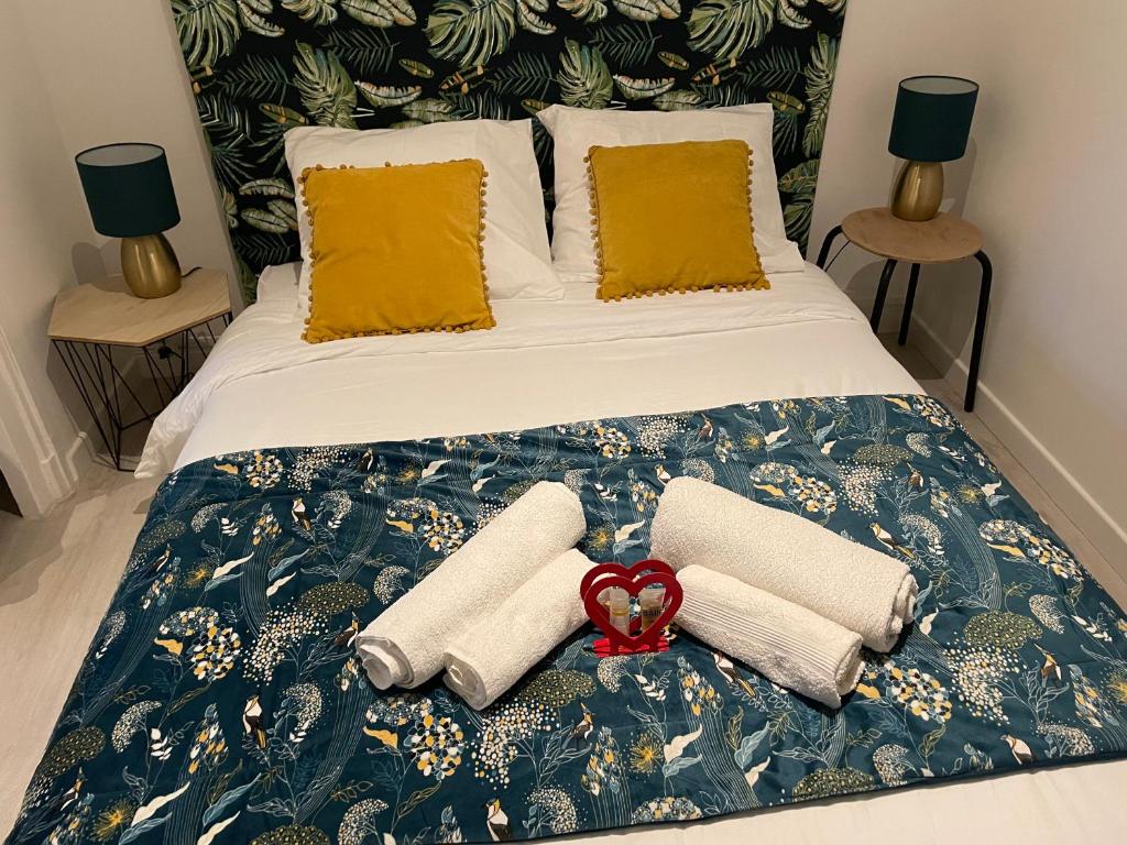 - un lit avec 2 serviettes et un ruban rouge dans l'établissement STUDIO VAISE 3 CENTRE à LYON 69009, à Lyon