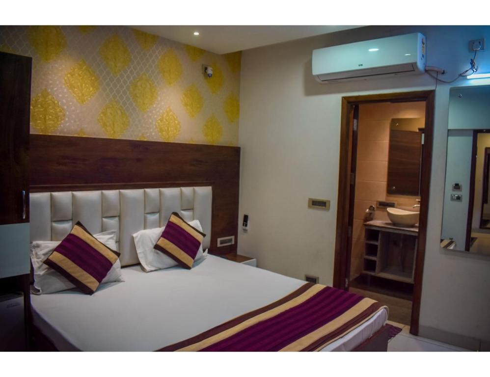 una camera da letto con un grande letto bianco con due cuscini di Hotel Sita Niwas Since 1965, Amritsar ad Amritsar