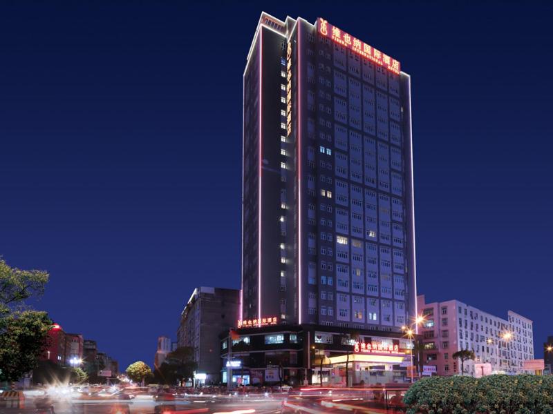 a tall building with lights on it at night at Vienna International Hotel FuJian PuTian Pearl in Putian