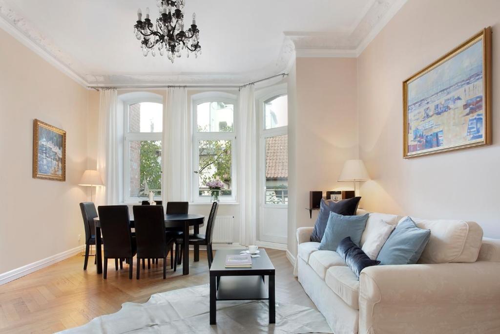 a living room with a white couch and a table at Elite Apartments Sopot Admiralski przy plaży in Sopot