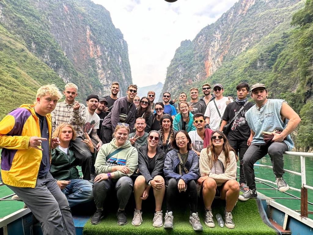 een groep mensen die poseren voor een foto voor een berg bij Bull Motorbikes and Tours in Làng Lap