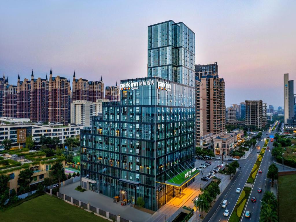 un montage d'un grand bâtiment en verre dans une ville dans l'établissement Park Inn by Radisson Chengdu Sihe Metro Station Xinchuan, à Chengdu