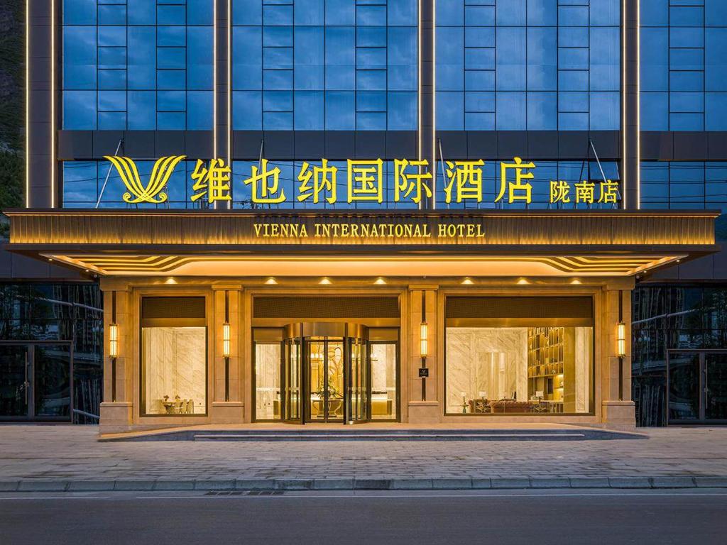 un bâtiment avec un panneau à l'avant dans l'établissement Vienna International Hotel Wudu Gujinli Longnan, à Longnan