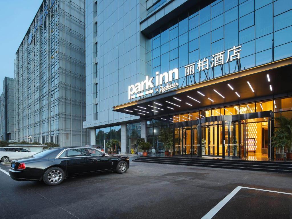 a black car parked in front of a building at Park Inn by Radission Tianjin Binhai International Airport in Tianjin