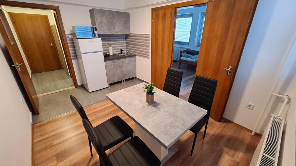 kuchnia i jadalnia ze stołem i krzesłami w obiekcie HÉDER APARTMANOK w mieście Balatonfenyves