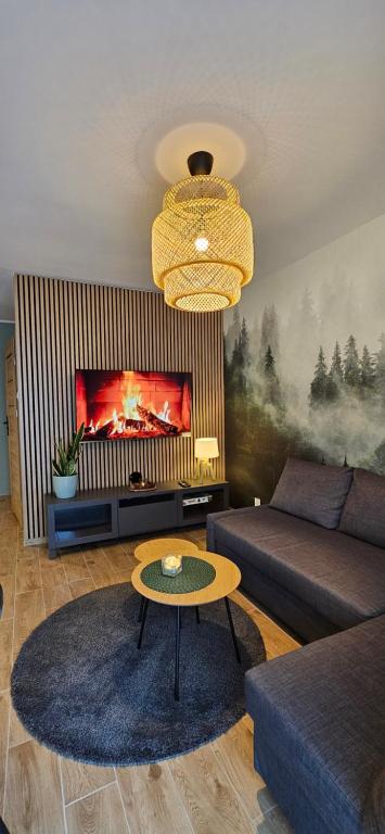 a living room with a couch and a table at Apartament Leśny Karpacz in Karpacz