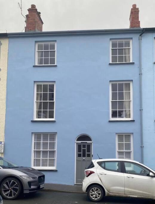 a blue house with two cars parked in front of it at Isfryn, holiday home in Aberdyfi in Aberdyfi