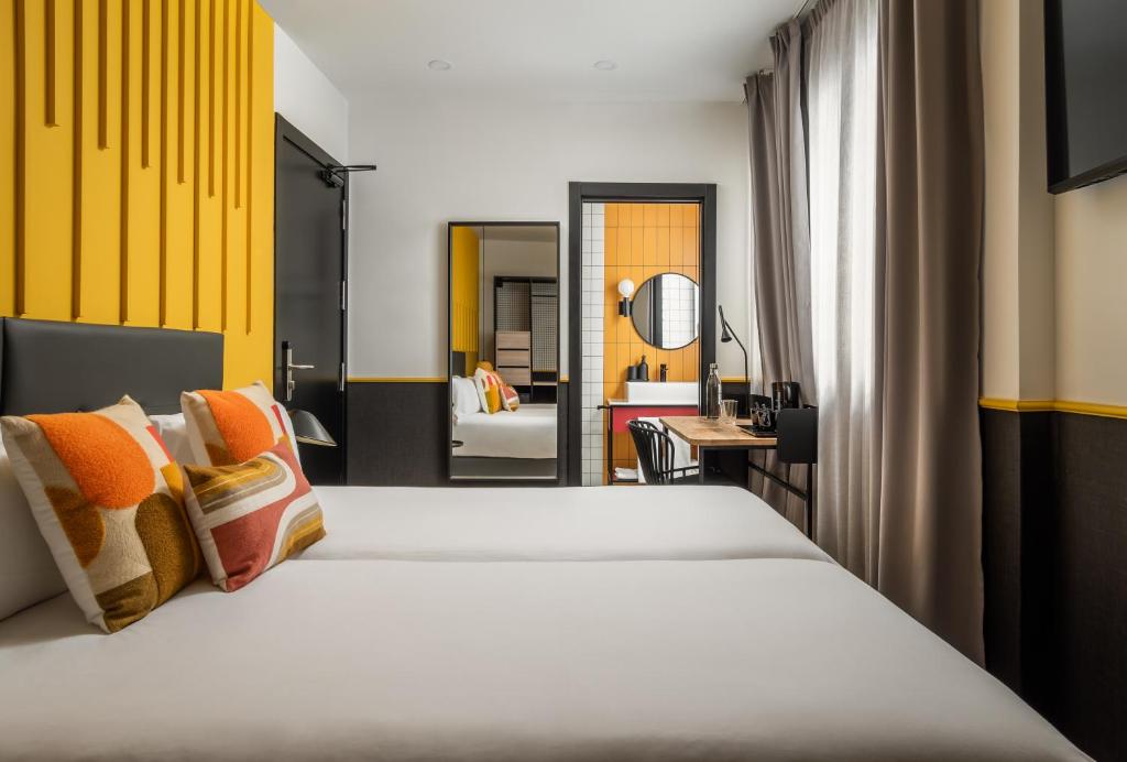 マドリードにあるBYPILLOW Crosstownのベッドとデスクが備わるホテルルームです。