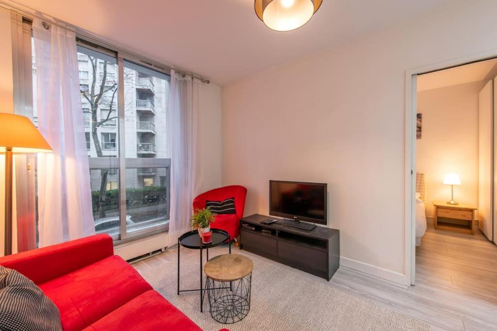 ein Wohnzimmer mit einem roten Sofa und einem roten Stuhl in der Unterkunft Parmentier - Cozy and confortable apartment in Neuilly-sur-Seine