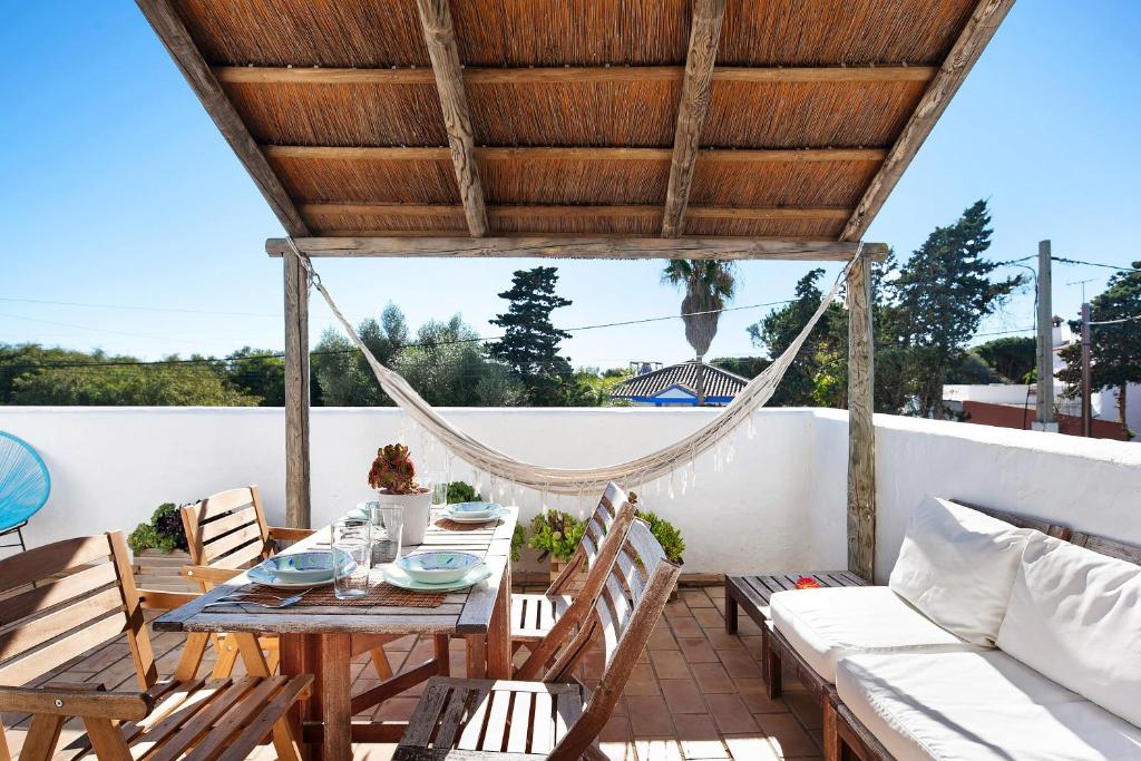 Un patio con mesa y sillas y una hamaca. en Varadero Beach Penthouse, en Los Caños de Meca