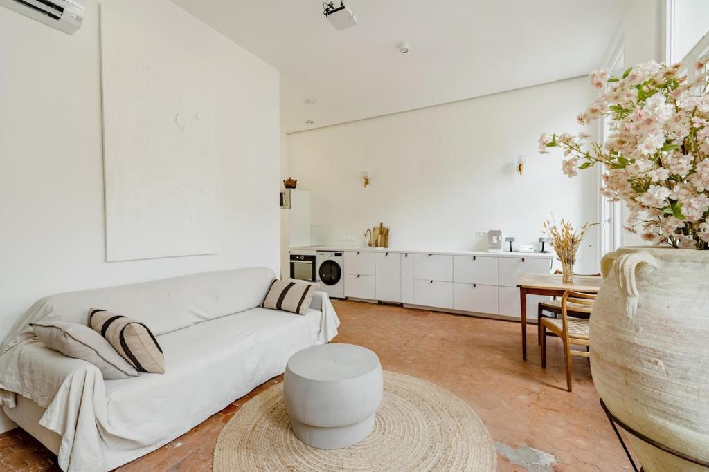 a white living room with a white couch and a table at |Aaa|- Pure &amp; Natural Massilia City Center in Marseille