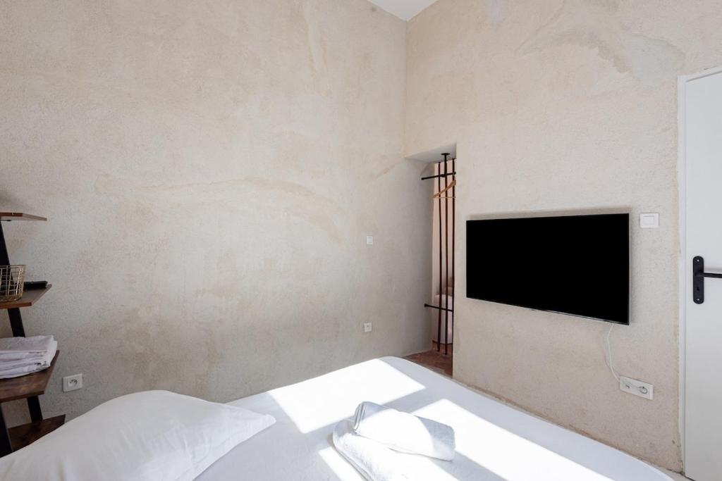 a bedroom with a bed and a television on the wall at |Aaa|- Pure &amp; Natural Massilia City Center in Marseille