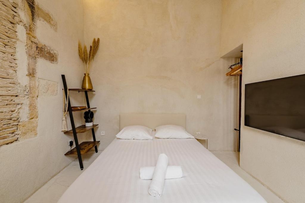 a bedroom with a bed with two white towels on it at |Aaa|- Pure &amp; Natural Massilia City Center in Marseille