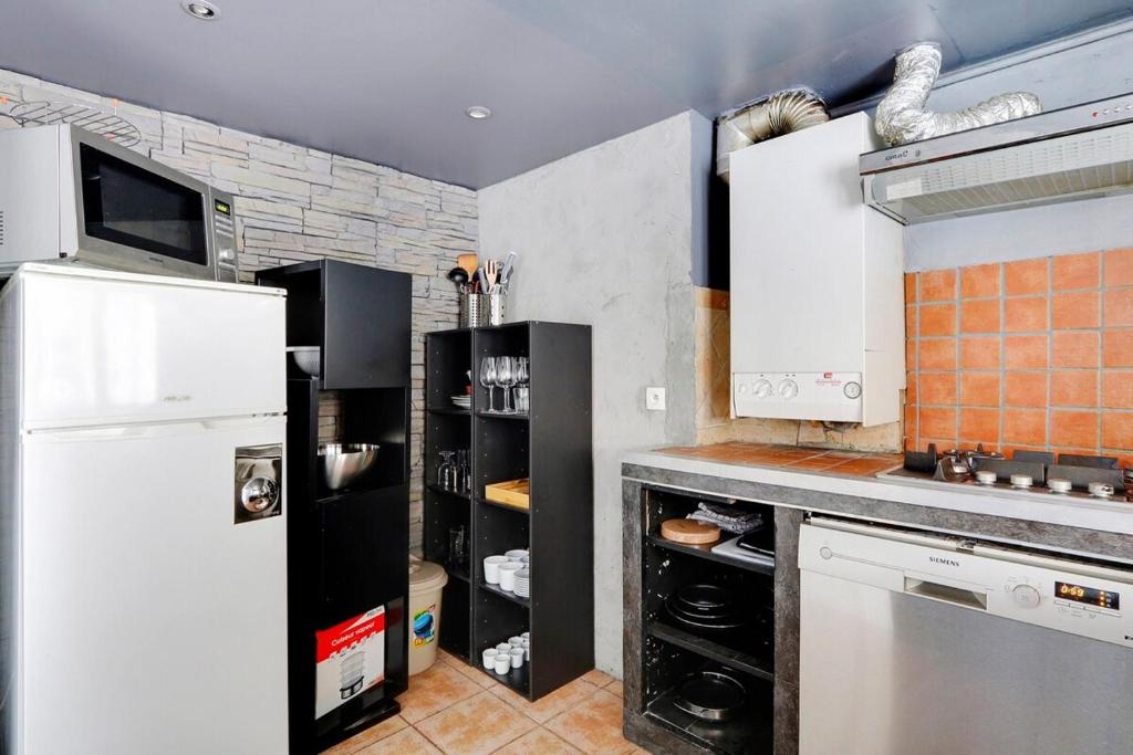 eine Küche mit einem weißen Kühlschrank und einem Herd in der Unterkunft Paris Marais Best WE MERRIS in Paris