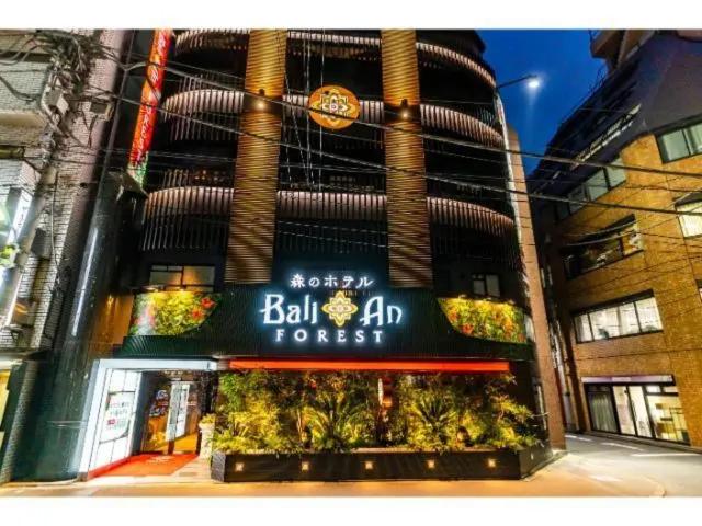 um edifício com um sinal na lateral em BaliAn Resort Forest Ikebukuro em Tóquio