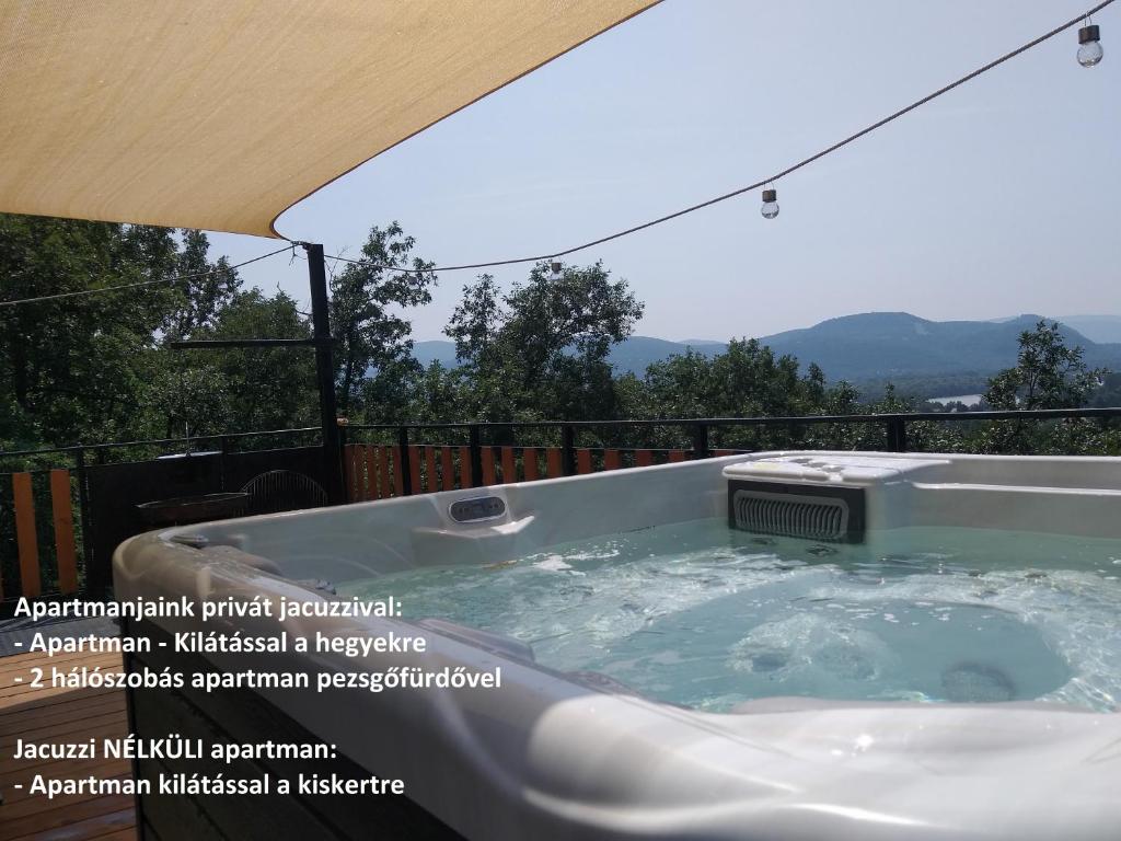 a jacuzzi tub on a balcony with a view at Tölgyerdő Apartman in Verőce