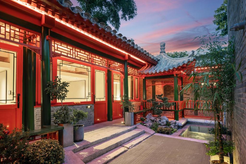 uma casa com uma fachada vermelha com plantas em Xinxiang Yayuan Beijing Sihe courtyard with sky garden terrace Near Tiananmen Square Forbidden City Wangfujing Pedestrian Street and the subway em Pequim