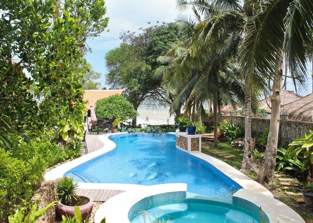 uma piscina num quintal com palmeiras em Sabbay Kep em Kep