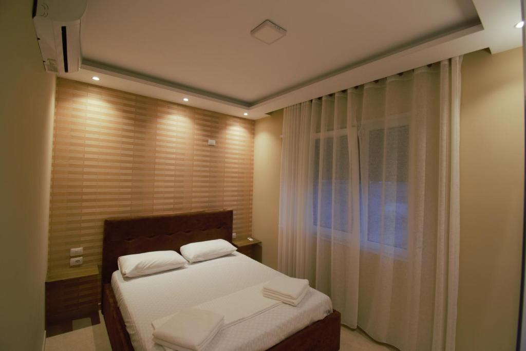 a bedroom with a bed with two white pillows at Residence Lux Apartments at VALAMAR Hamallaj Gjiri Lalzit in Durrës