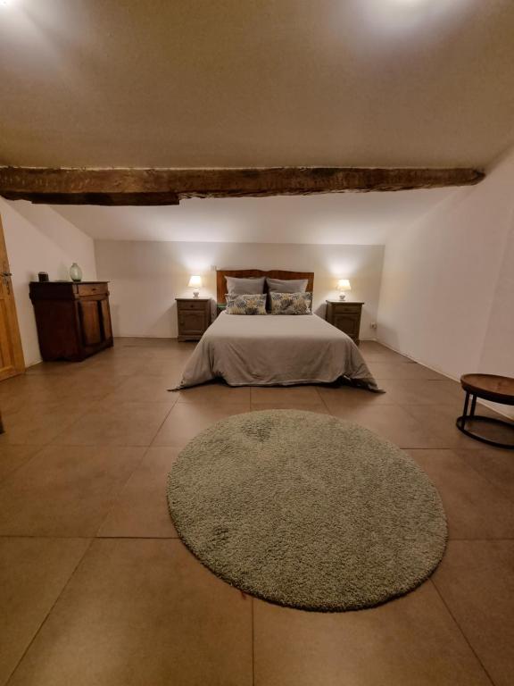 a large bedroom with a bed and a rug at Chambres entre Ventoux et luberon in Sault-de-Vaucluse