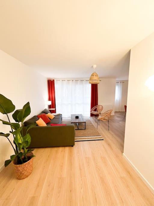 un salon avec un canapé vert et une table dans l'établissement La Baugerie enchantée, à Saint-Sébastien-sur-Loire