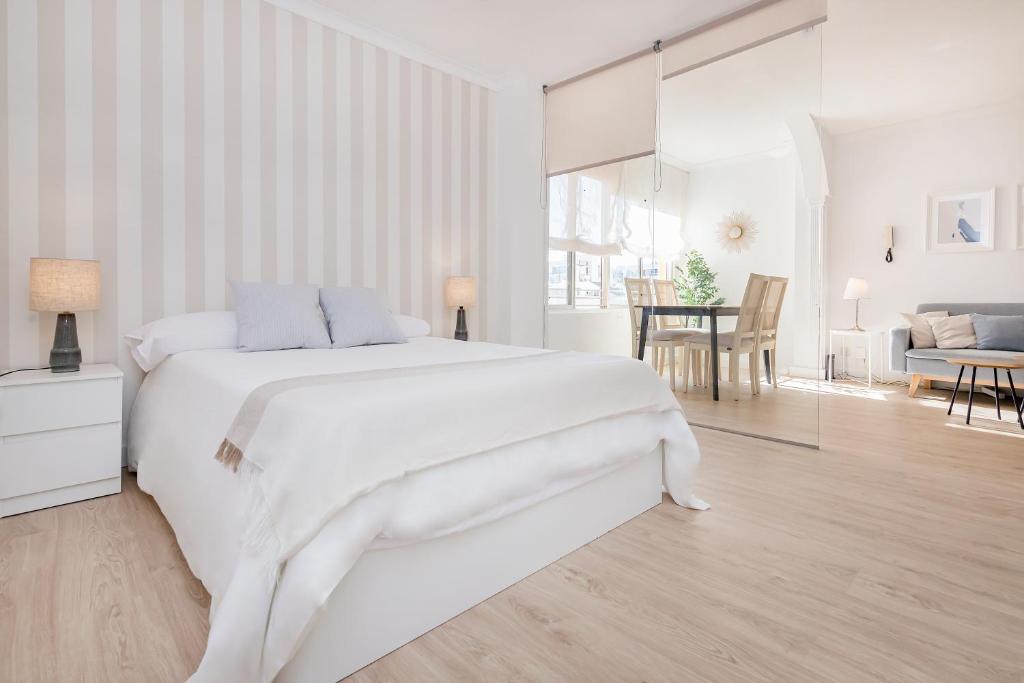 - une chambre blanche avec un grand lit et une salle à manger dans l'établissement Marbella center Casals, à Marbella