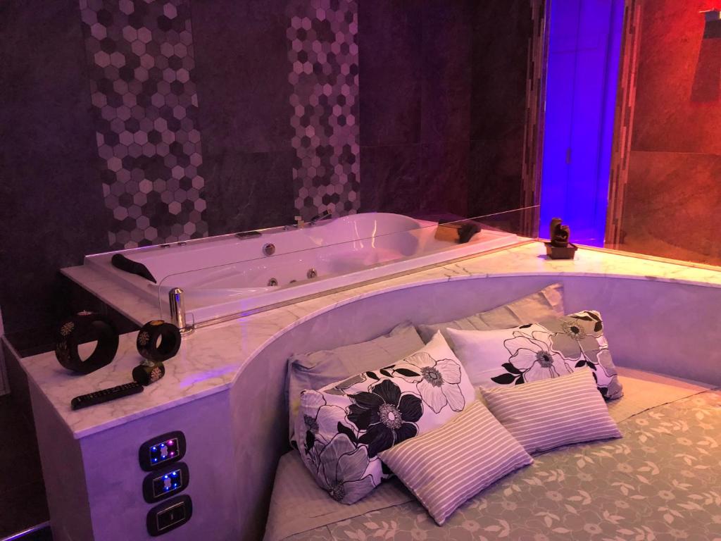 uma cama com banheira num quarto com almofadas em Assisi Luxury SPA Suite em Assis