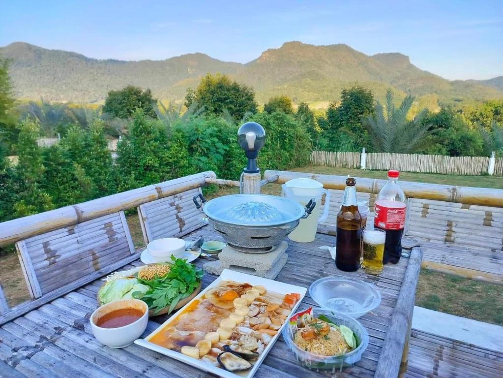 a picnic table with food and drinks on a deck at Quality Time farm stay: Yard house in Ban Pa Lau