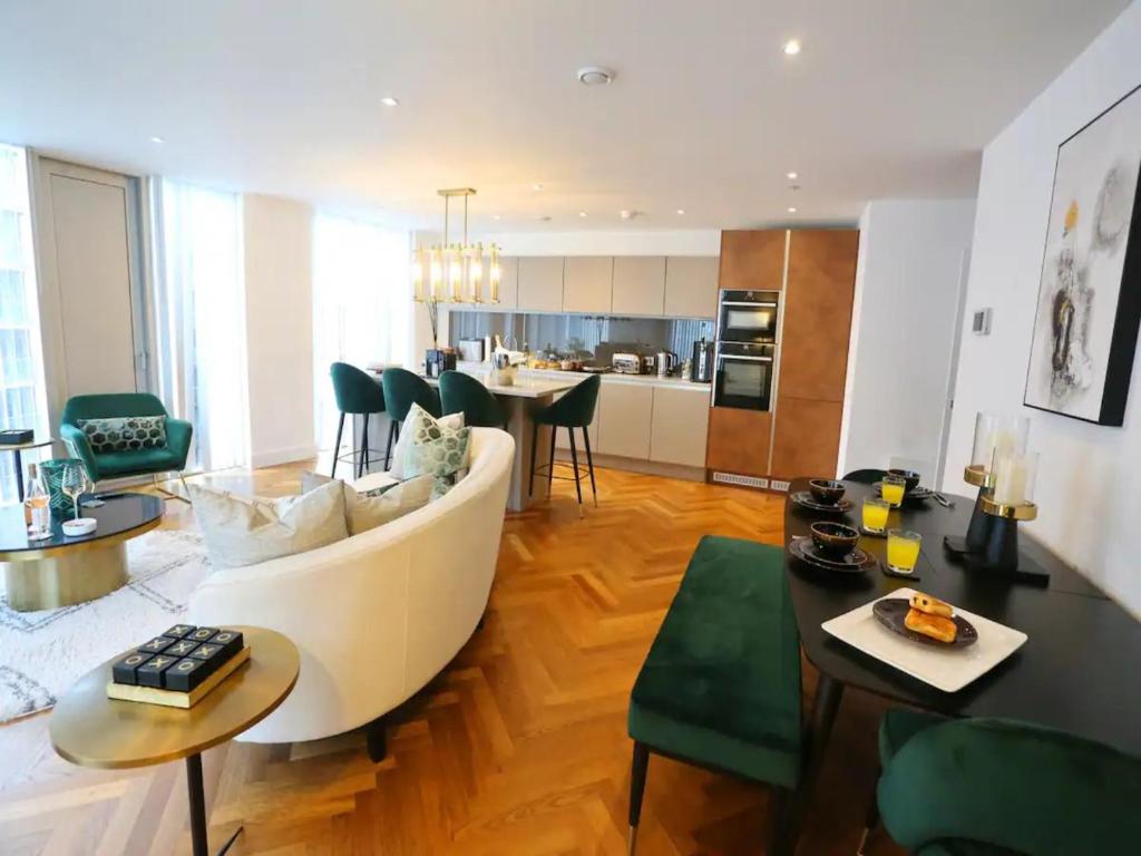 uma sala de estar com um sofá branco e uma cozinha em Pass the Keys Central 3x King Bed Suite 5 Min Deansgate Station em Manchester