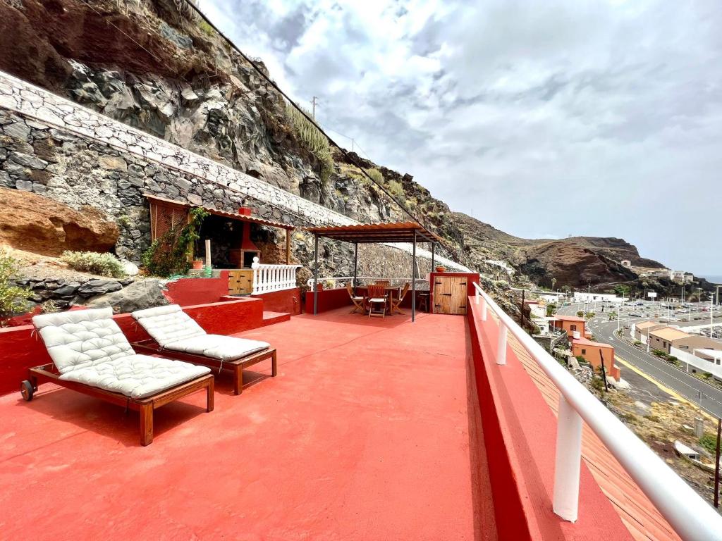 balcón con sillas y vistas a la montaña en Atico de 2 dormitorios con vista al Mar, a 100 m de playa, en Puerto de la Estaca