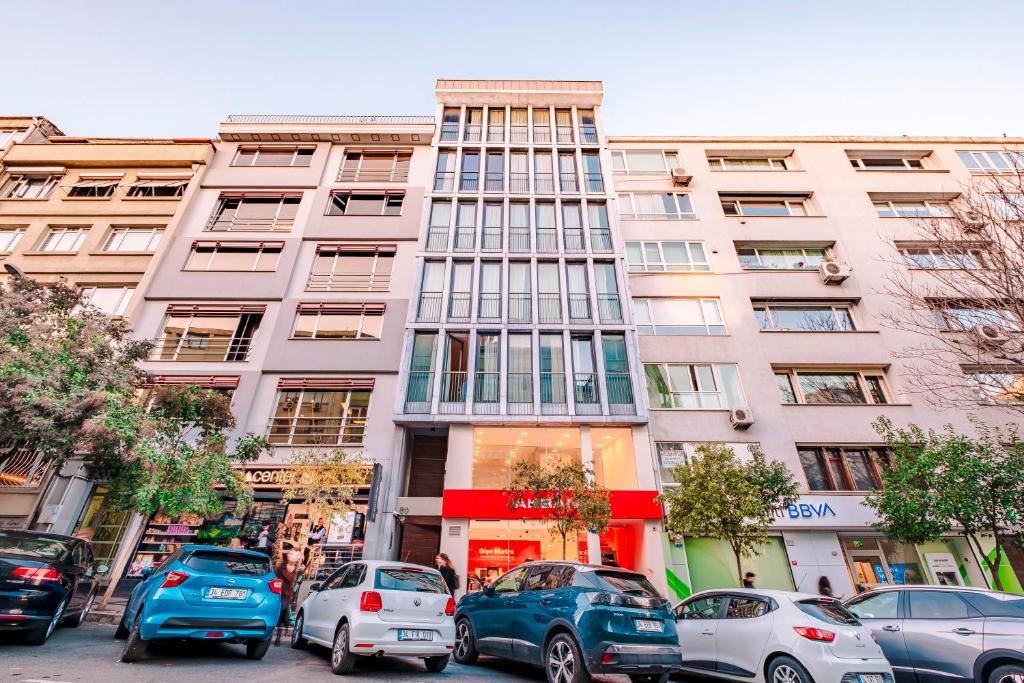 um edifício alto com carros estacionados em frente em Homie Suites - Luxury Apartments in Maçka em Istambul