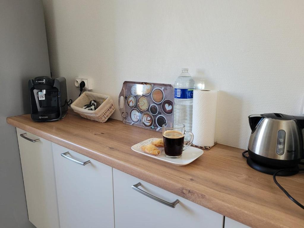 a counter top with a cup of coffee and a toaster at La Compiègnoise - Spacieux - Lumineux - Cosy in Compiègne