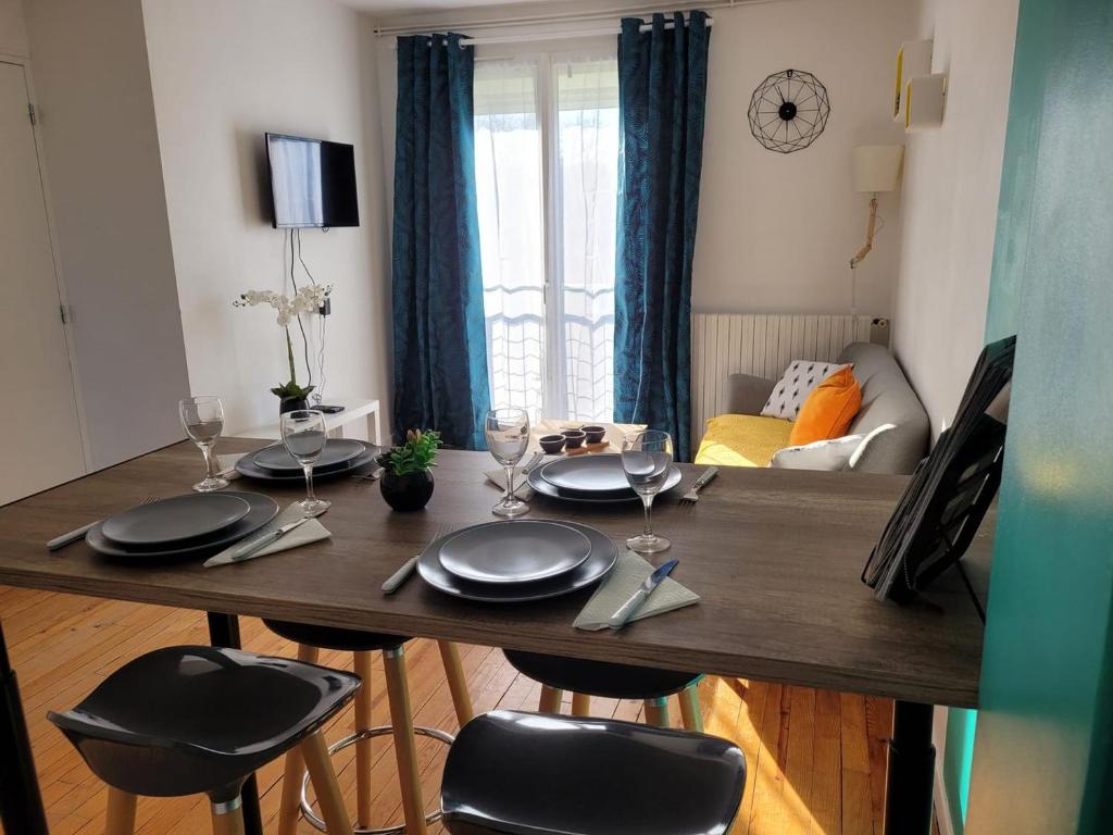 a dining room table with black chairs and a dining room at La Compiègnoise - Spacieux - Lumineux - Cosy in Compiègne