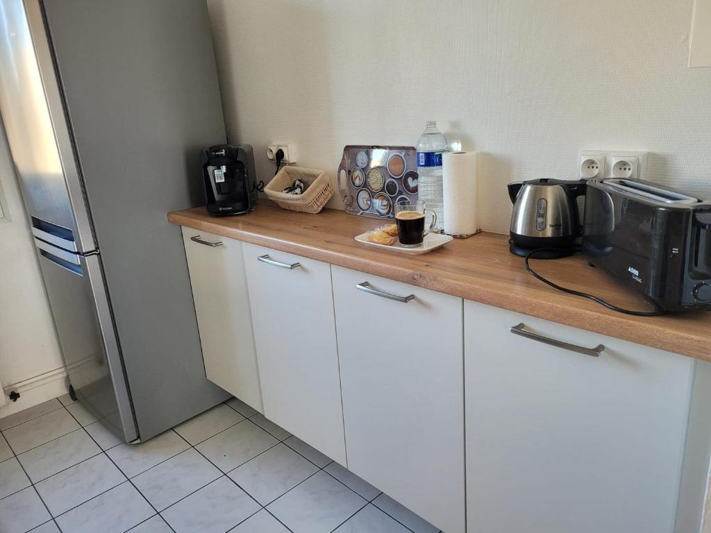 a kitchen with a counter with a toaster and a microwave at La Compiègnoise - Spacieux - Lumineux - Cosy in Compiègne