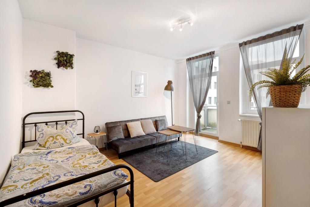 um quarto com uma cama e um sofá em Wohnen am Wissenschaftshafen em Magdeburg