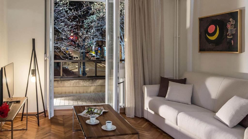 a living room with a white couch and a large window at Apartment Balkan in Belgrade