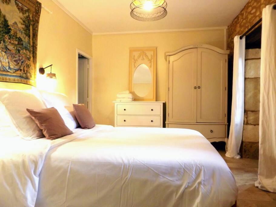 1 dormitorio con 1 cama blanca grande y vestidor en Domaine de La Barde apartments in the old walnut mill and forge, en Le Bugue