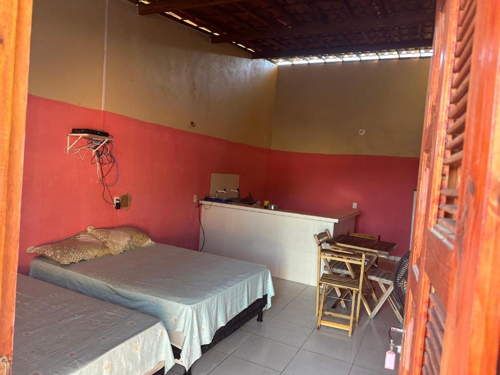 um quarto com 2 camas e uma parede vermelha em Casa 2 Gold Star Village em Majorlândia