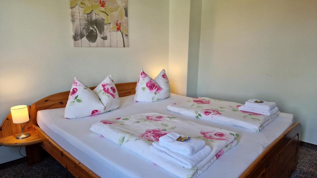 two beds in a room with towels and pillows at Gästehaus Wilsickow in Uckerland