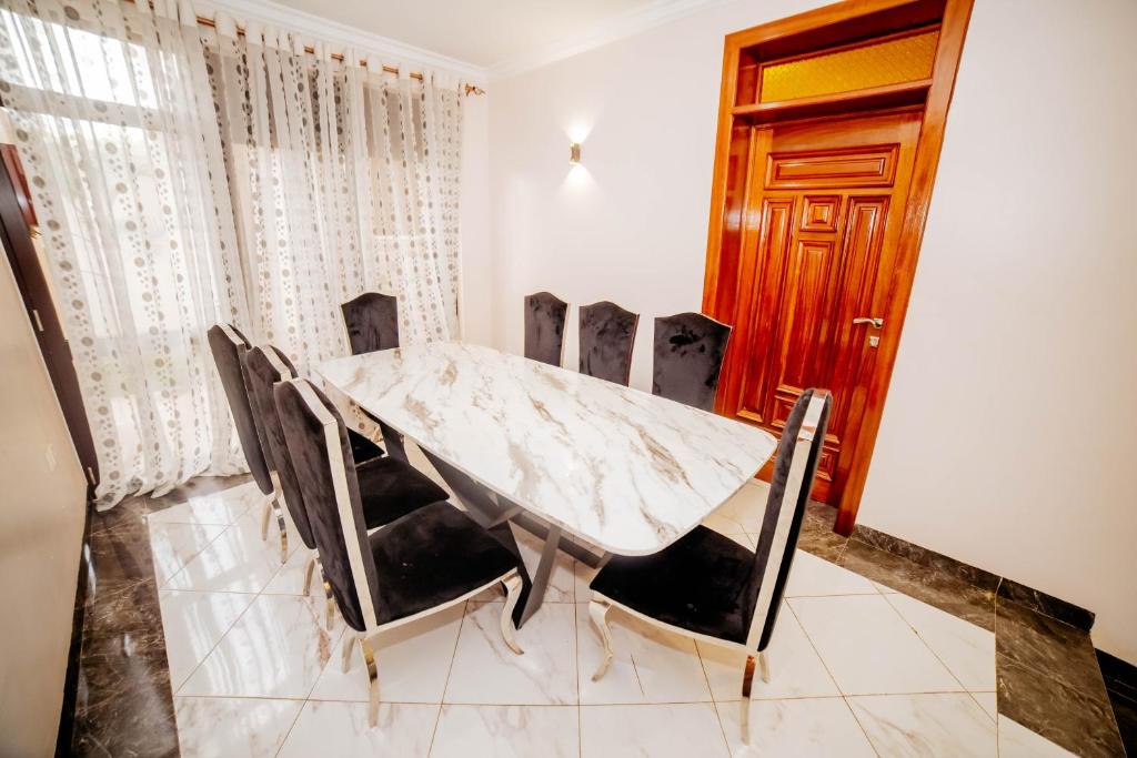 a dining room with a marble table and chairs at The Palaixon in Bujumbura
