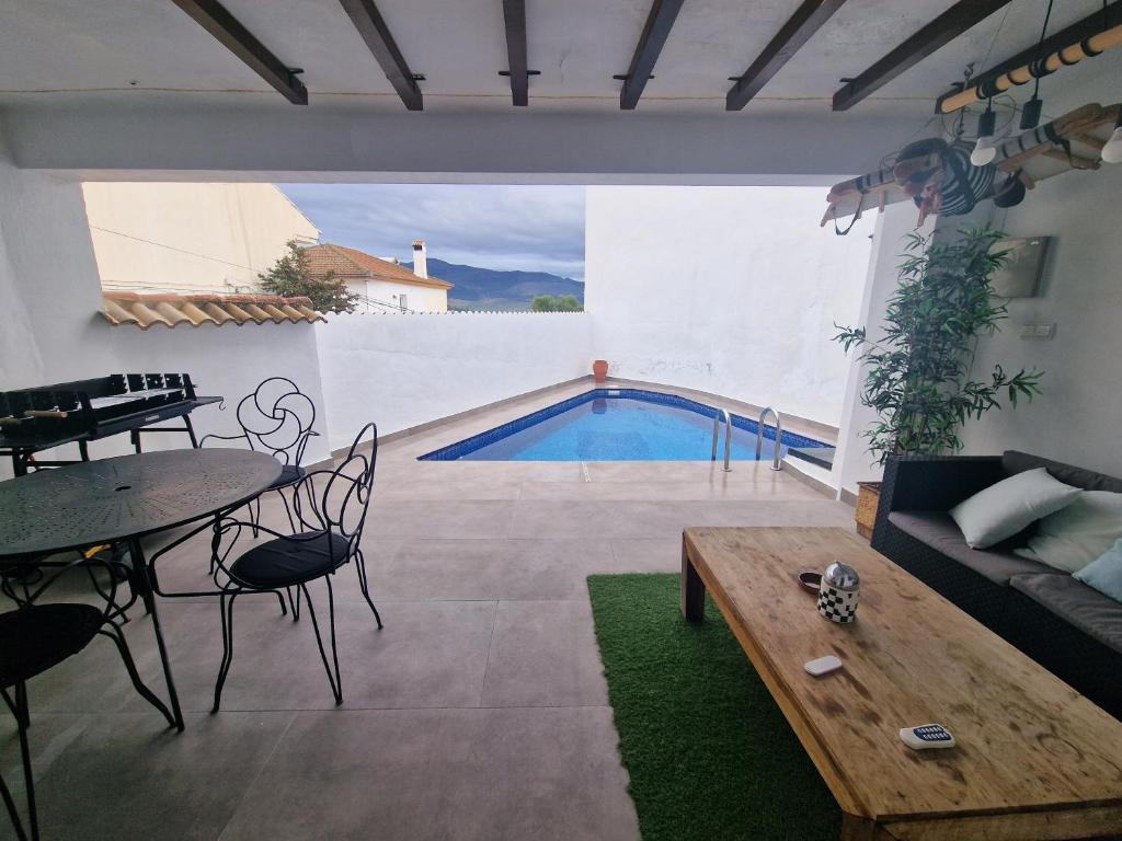 a living room with a table and a swimming pool at Casa Clavel in Ronda