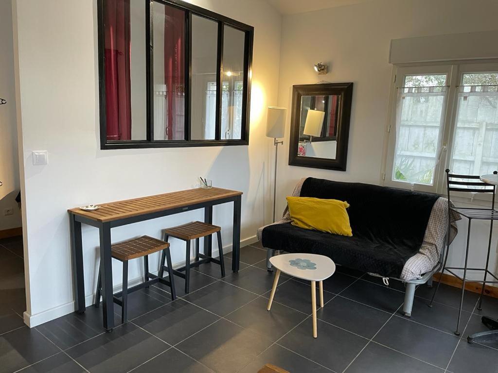 uma sala de estar com um sofá e uma mesa em Les toits Vendôme em Lagord