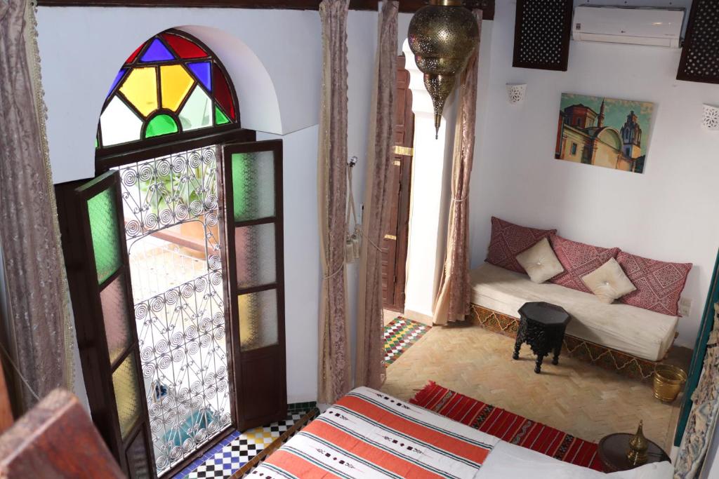 a living room with a couch and a stained glass window at Dar Saray in F&egrave;s