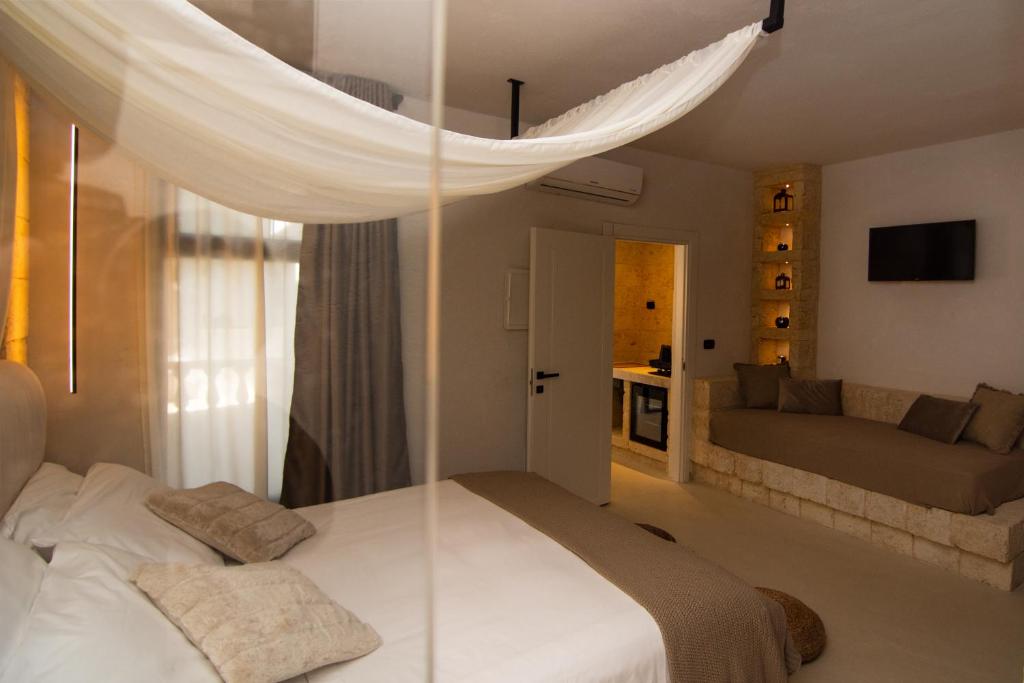 a bedroom with a bed and a couch in a room at Borgo Bevagna Relais in San Pietro in Bevagna