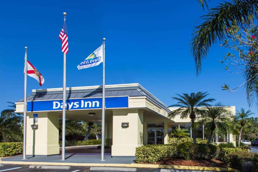 a dealership with two flags in front of it at Days Inn by Wyndham Melbourne in Melbourne