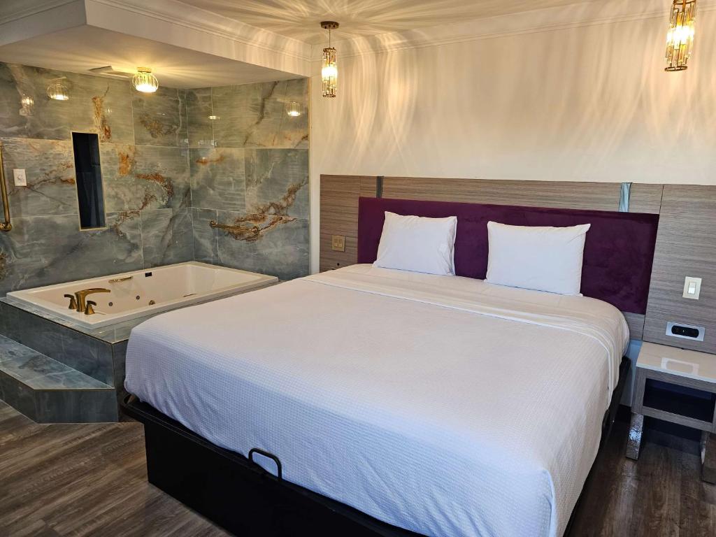 a bedroom with a bed and a bath tub at Travelodge Inn & Suites by Wyndham Fullerton in Fullerton