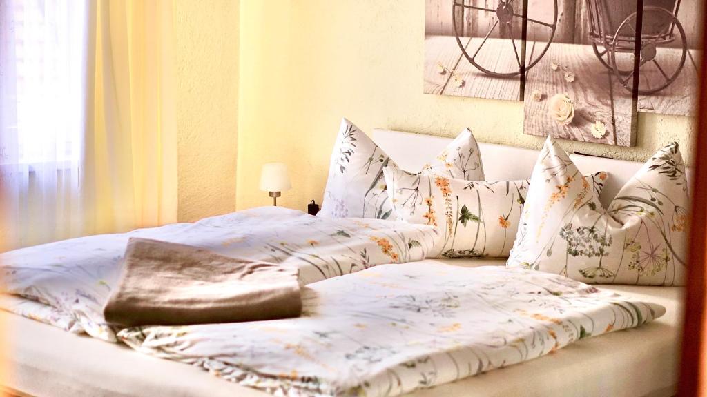 um quarto com 2 camas e almofadas brancas em Pension Zum Lukullus em Wernigerode