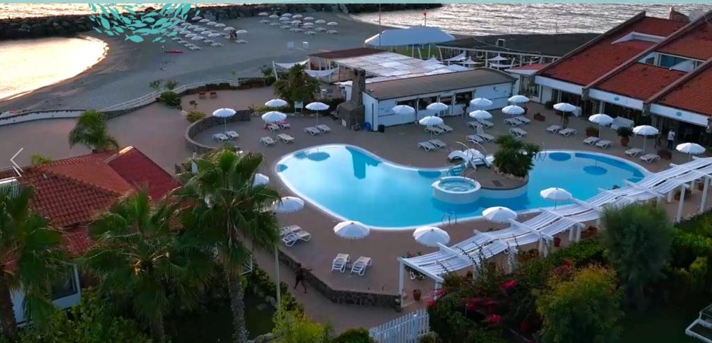 アマンテーアにあるLe Mandrelle Beach Resortのスイミングプール付きのリゾートの空中ビュー