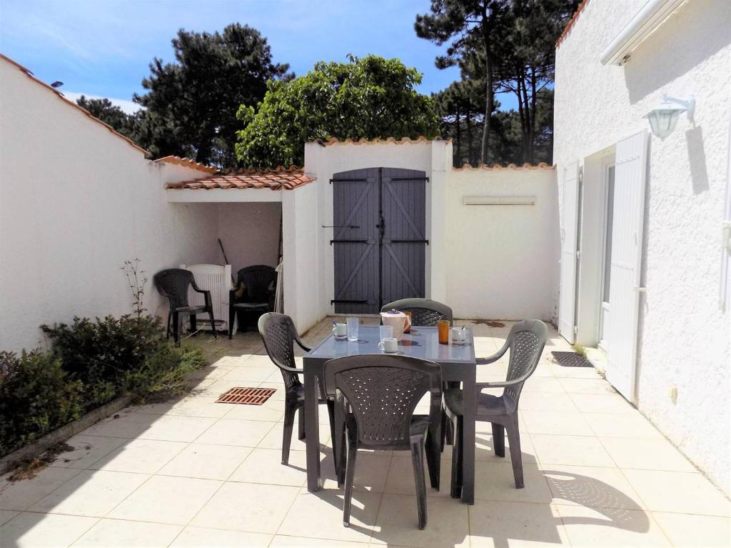 une table et des chaises assises sur une terrasse dans l'établissement La Palmyre - TREMIERES - VILLA MITOYENNE - PROXIMITE PLAGE et CENTRE, aux Mathes