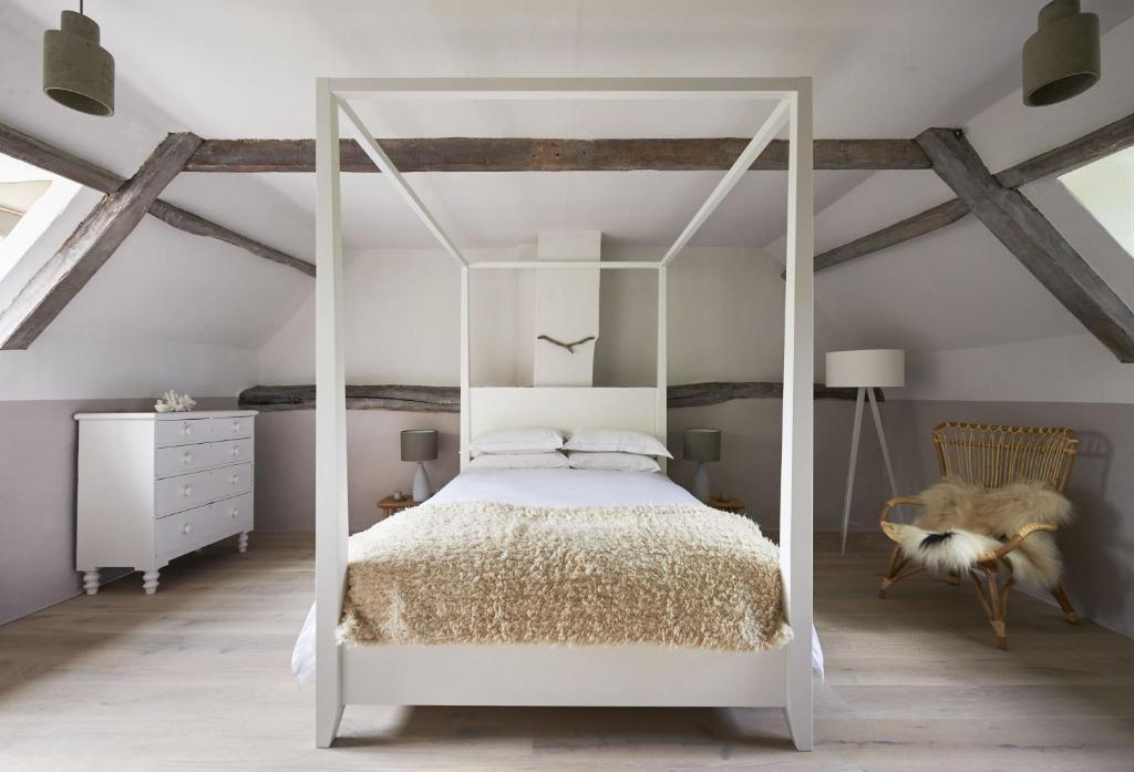 a bedroom with a white canopy bed and a dresser at Salt in Sharrington